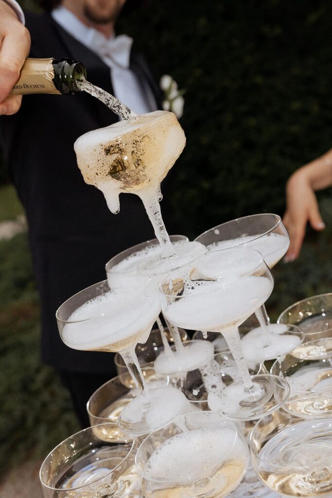 Champagner wird bei der Hochzeitsfeier von Sali und Szymon im Schloss Schönau in Gläser eingeschenkt.