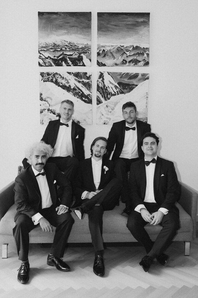Szymon mit seinen Groomsmen in eleganten schwarzen Anzügen bei einem gemeinsamen Gruppenfoto.